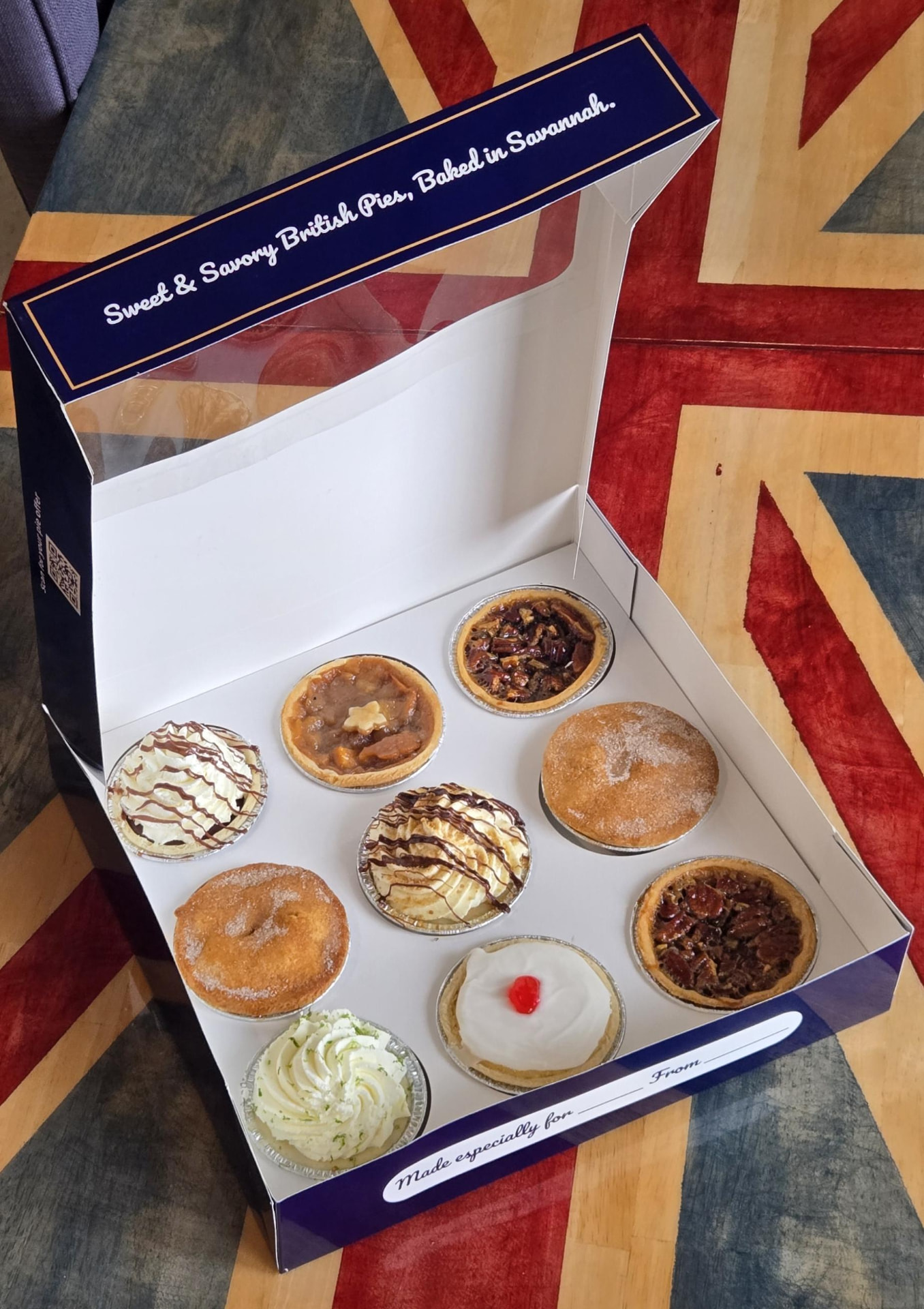 An open Pie Society box filled with assorted mini pies